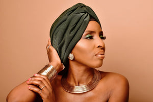 Model wearing Jarlia By Jolina’s jewellery set, featuring a bold gold choker, matching cuff bracelet, and statement earrings. This luxurious set embodies timeless elegance and cultural sophistication. Explore the full jewellery sets collection.
