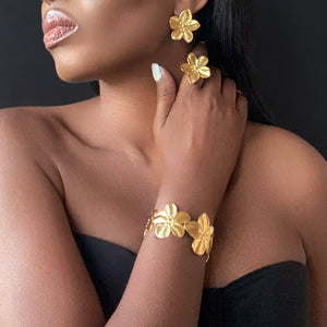Model wearing Jarlia By Jolina’s Luxe Jewellery, featuring a gold floral bracelet, matching ring, and earrings. This elegant set embodies sophistication and timeless beauty. Explore the Luxe Collection for premium gold-plated designs.