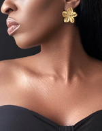 Cargar imagen en el visor de la galería, Model showcasing ABYDOS Big Flower Earrings by Jarlia By Jolina, featuring bold 18k gold-plated floral design, perfect for elevating any outfit with timeless elegance.

